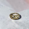 22K gold leaf link finger ring on grey stone surface