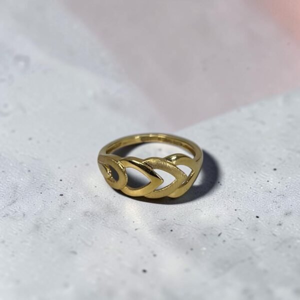 22K gold leaf link finger ring on grey stone surface